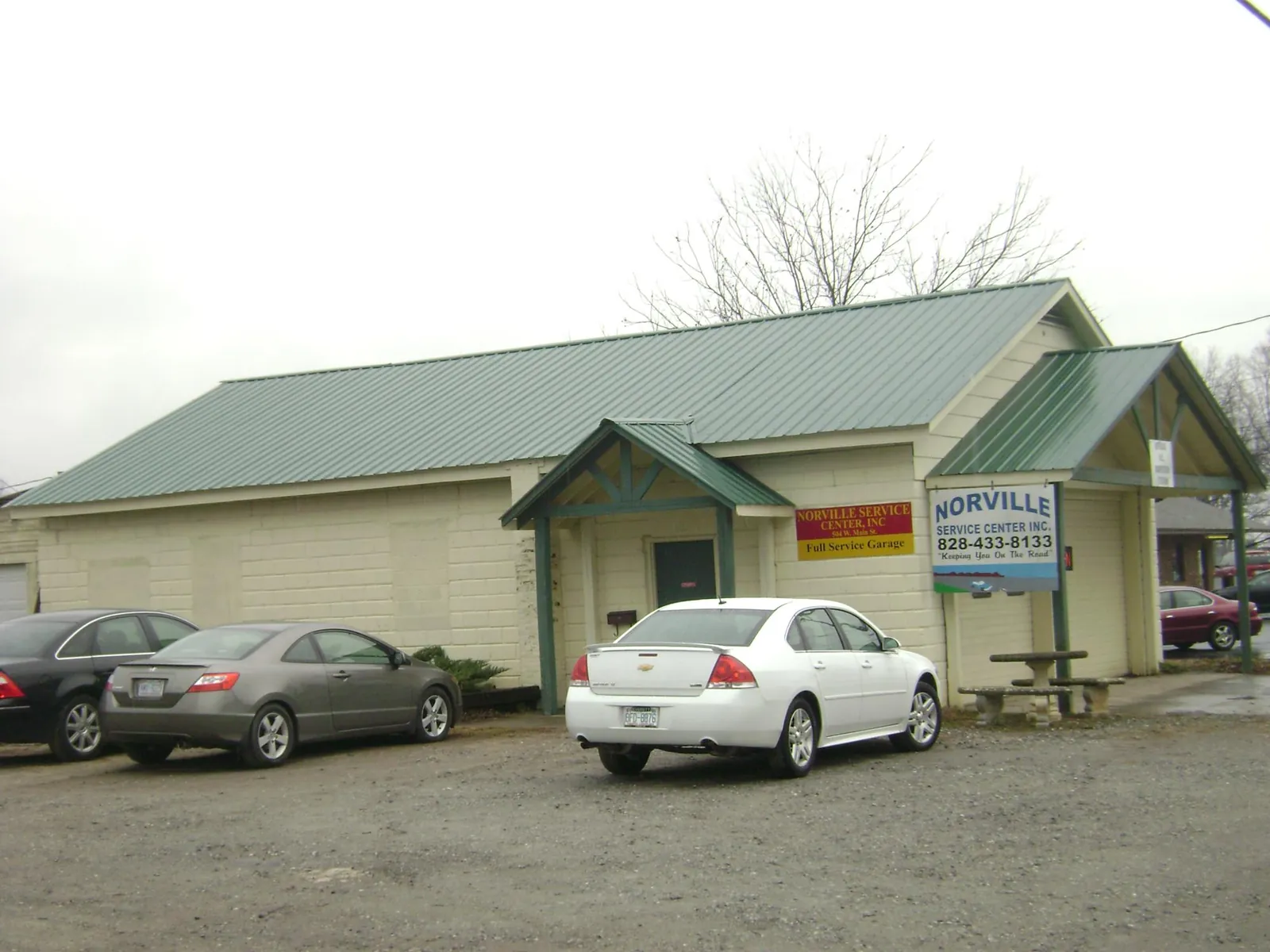 Green metal roof on a service garage with a covered entry in Aurora